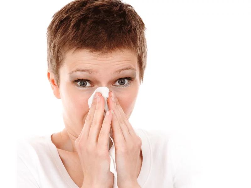 lady sneezing on tissue