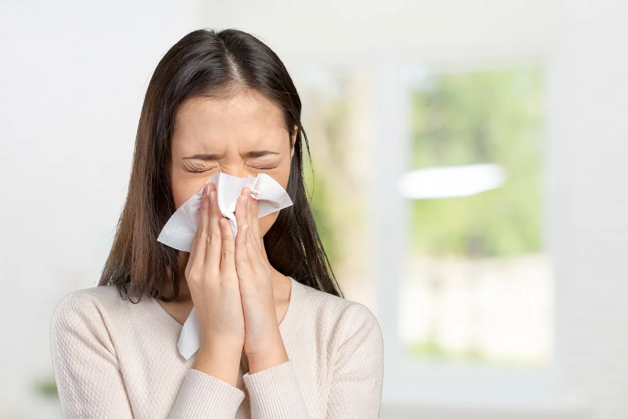 A woman with a cold sneezing