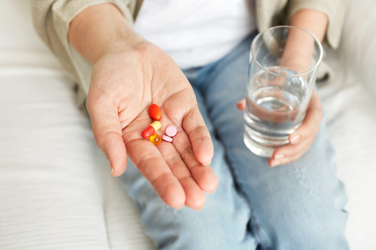 A COVID-positive person taking vitamins and medication